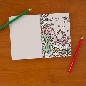 The interior of the Ocean Life coloring book depicting an octupus, coral, and fish.  A green and a red colored pencil sit nearby. 