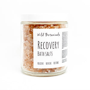 A display photo fo a clear jar of bath salts with a label reading "Wile Botanicals Recover Bath Salts". 