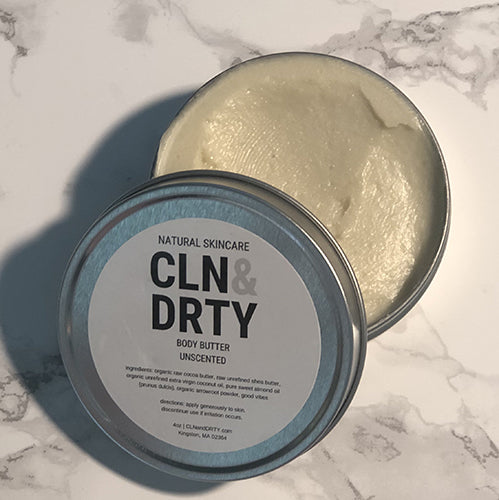 A tin of body butter is open with a label reading "Natural Skincare CLN&DRTY body butter". 