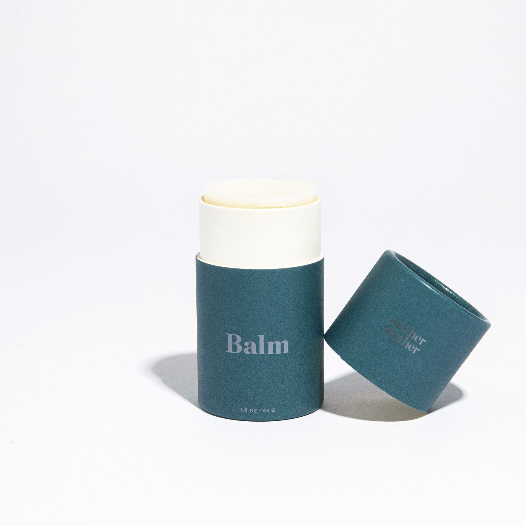 Mother Mother Balm is open displaying a creamy light colored balm. 
