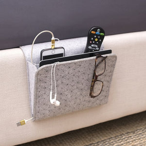 A light grey pocket to attach to the side of your bed holds a book, electronics, pen, and phone.